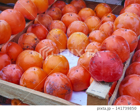 Ripe sweet juicy persimmon on market stall, delicious dessert Ripe sweet juicy persimmon on market stall, delicious dessert 141739850