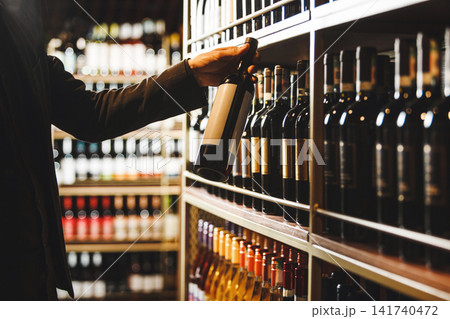 Sommelier Selecting Fine Wine Bottle From Cellar Collection While Consulting Description Sommelier Selecting Fine Wine Bottle From Cellar Collection While Consulting Description 141740472