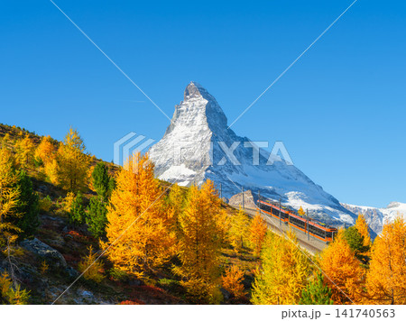 Passenger train on a railway in Switzerland. Autumn nature in the Alps.  141740563