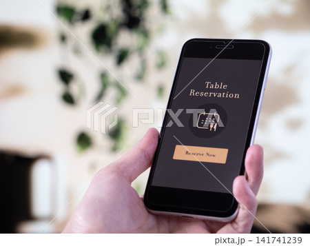 レストランや飲食店用のオンライン予約アプリを表示したスマホ写真(画面デザインはオリジナル制作) レストランや飲食店用のオンライン予約アプリを表示したスマホ写真(画面デザインはオリジナル制作) 141741239