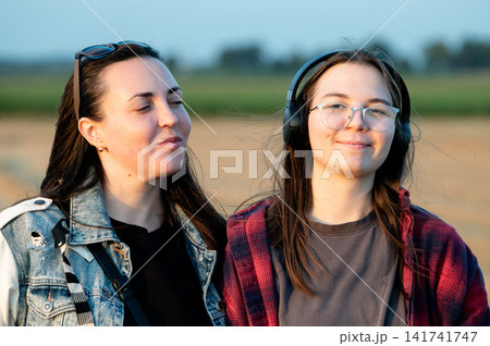 Two Women Watching Planes With Aviation Headphones Two Women Watching Planes With Aviation Headphones 141741747