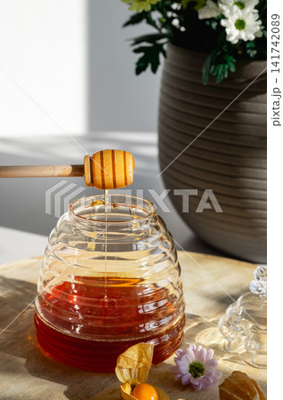 Drizzling Honey into a Beehive Jar by Flowers Drizzling Honey into a Beehive Jar by Flowers 141742089