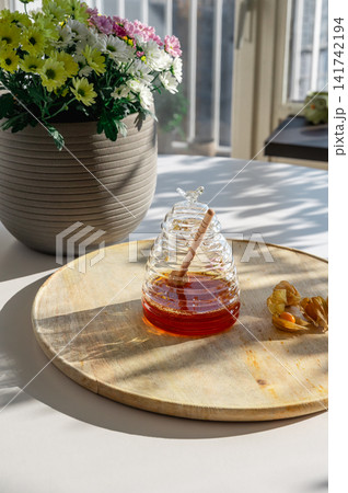 Honey Jar on a Wooden Board with Summer Flowers Honey Jar on a Wooden Board with Summer Flowers 141742194