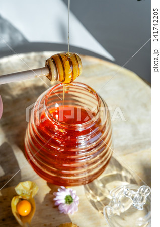 Close-up of Honey Dripping into a Glass Jar 141742205