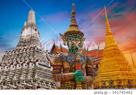 Colorful giant guardian statue with iconic temples and Grand Palace in Bangkok, Thailand. Colorful giant guardian statue with iconic temples and Grand Palace in Bangkok, Thailand. 141742482