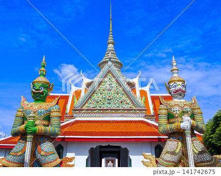 Colorful giant guardian statue at Wat Phra Kaew with traditional Thai temple architecture in Bangkok. Colorful giant guardian statue at Wat Phra Kaew with traditional Thai temple architecture in Bangkok. 141742675