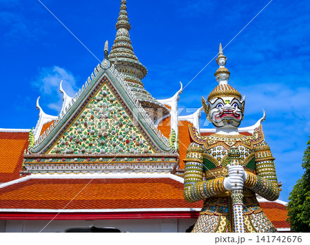 Colorful giant guardian statue at Wat Phra Kaew with traditional Thai temple architecture in Bangkok. Colorful giant guardian statue at Wat Phra Kaew with traditional Thai temple architecture in Bangkok. 141742676