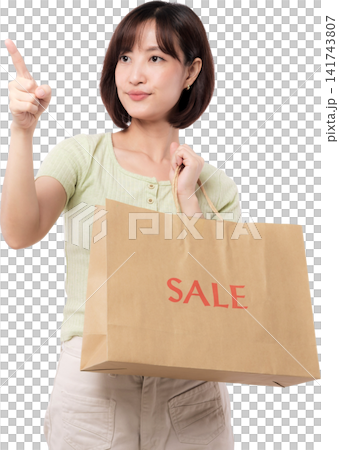Happy young asian woman holding brown shopping bag and pointing finger up with confident expression on white studio background Happy young asian woman holding brown shopping bag and pointing finger up with confident expression on white studio background 141743807