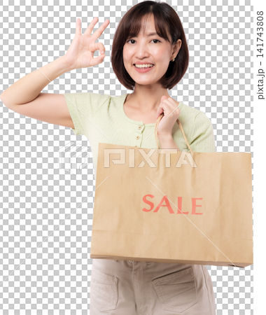 Happy asian woman holding paper bag making okay sign gesture showing cheerful smile during discount shopping sale period transparency Happy asian woman holding paper bag making okay sign gesture showing cheerful smile during discount shopping sale period transparency 141743808