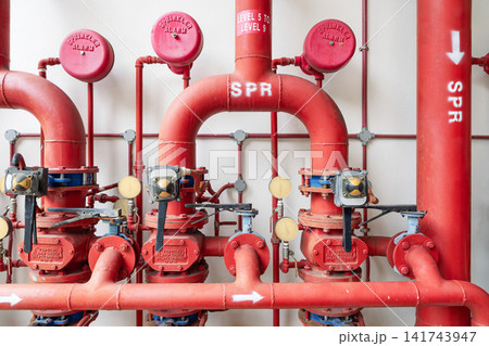 Industrial fire sprinkler system with red pipes and alarm valves for building safety Industrial fire sprinkler system with red pipes and alarm valves for building safety 141743947