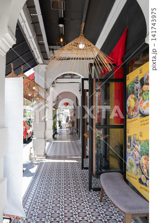 Vibrant outdoor corridor featuring decorative lighting, patterned tiles, and colorful restaurant signage, creating an inviting atmosphere for dining and socializing experiences Vibrant outdoor corridor featuring decorative lighting, patterned tiles, and colorful restaurant signage, creating an inviting atmosphere for dining and socializing experiences 141743975