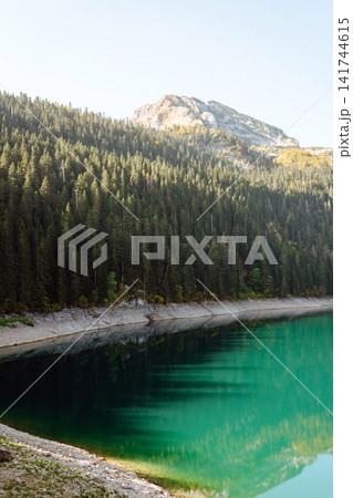 Incredible view in mountains of the lake. Rocky shore of mountain lake in the morning. Incredible view in mountains of the lake. Rocky shore of mountain lake in the morning. 141744615