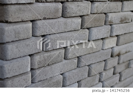 Stack of grey concrete paving stones and interlocking blocks, construction materials and hardscaping background Stack of grey concrete paving stones and interlocking blocks, construction materials and hardscaping background 141745256