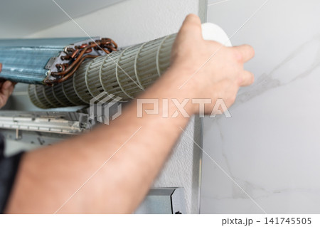 Man technician cleaning air conditioner fan. Professional maintenance and repair of cooling system. Man technician cleaning air conditioner fan. Professional maintenance and repair of cooling system. 141745505