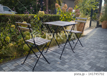 Empty folding metal tables and chairs on paved terrace outdoors Empty folding metal tables and chairs on paved terrace outdoors 141745702
