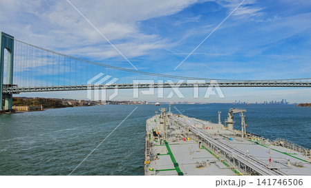 Large oil chemical tanker vessel navigating under Verrazzano Narrows suspension bridge toward New York bay harbour for maritime shipping and freight transport concept Large oil chemical tanker vessel navigating under Verrazzano Narrows suspension bridge toward New York bay harbour for maritime shipping and freight transport concept 141746506