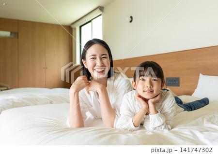 ベッドに寝転がる親子 ベッドに寝転がる親子 141747302