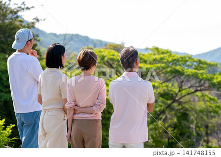 別荘地から景色を眺める二世代家族の後ろ姿 別荘地から景色を眺める二世代家族の後ろ姿 141748155