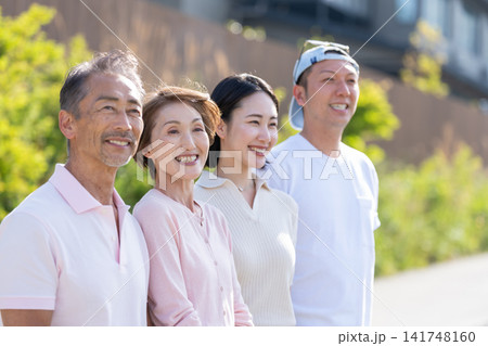 屋外で笑顔で並ぶシニア夫婦と若い夫婦 屋外で笑顔で並ぶシニア夫婦と若い夫婦 141748160