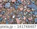 Top View of Colorful Small Stones and Crushed Granite Pebbles on Sandy Ground 141748407