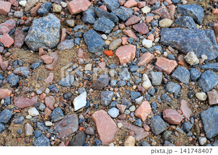 Top View of Colorful Small Stones and Crushed Granite Pebbles on Sandy Ground Top View of Colorful Small Stones and Crushed Granite Pebbles on Sandy Ground 141748407