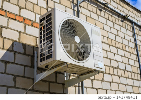 Side View of Outdoor Air Conditioning Unit Mounted on Brick Building Wall Side View of Outdoor Air Conditioning Unit Mounted on Brick Building Wall 141748411
