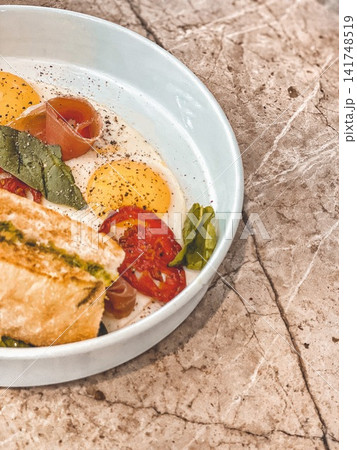 Sunny side eggs with toast and vegetables on table, warm light, breakfast scene Sunny side eggs with toast and vegetables on table, warm light, breakfast scene 141748519