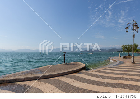 Lungolago Marconi beside Lake Garda in Lazise with patterned paving and ornate lamps Lungolago Marconi beside Lake Garda in Lazise with patterned paving and ornate lamps 141748759