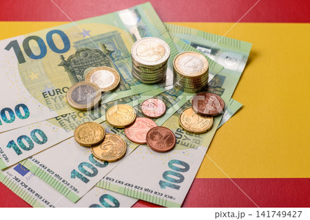 Spain, Spanish euro cash and cent coins against the background of the flag. Euro cash Spain, Spanish euro cash and cent coins against the background of the flag. Euro cash 141749427