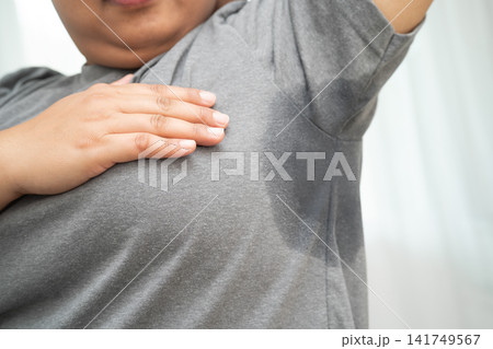 Sweaty underarms, Asian woman with sweat on clothes under armpit. Sweaty underarms, Asian woman with sweat on clothes under armpit. 141749567
