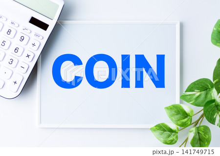 COIN(コイン)の文字のホワイトボードと白い電卓 COIN(コイン)の文字のホワイトボードと白い電卓 141749715