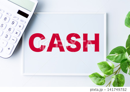CASH(キャッシュ)の文字のホワイトボードと白い電卓 CASH(キャッシュ)の文字のホワイトボードと白い電卓 141749782