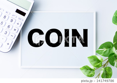 COIN(コイン)の文字のホワイトボードと白い電卓 COIN(コイン)の文字のホワイトボードと白い電卓 141749786