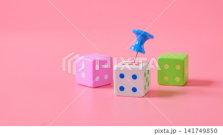 Push pin on dice game on color background. Push pin on dice game on color background. 141749850