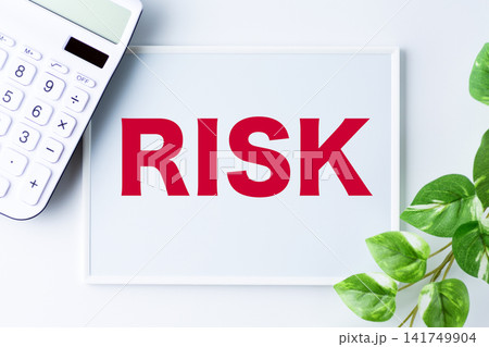 RISK（リスク）の文字のホワイトボードと白い電卓 141749904