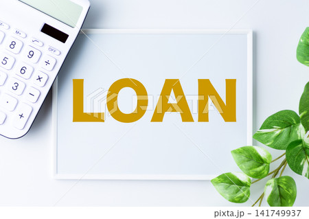 LOAN(ローン)の文字のホワイトボードと白い電卓 LOAN(ローン)の文字のホワイトボードと白い電卓 141749937