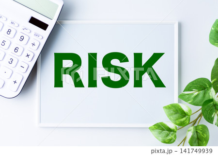 RISK(リスク)の文字のホワイトボードと白い電卓 RISK(リスク)の文字のホワイトボードと白い電卓 141749939