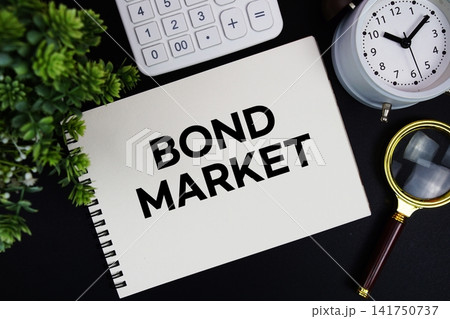 Bond Market text written on notepad with alarm clock, magnifying glass and calculator on black background Bond Market text written on notepad with alarm clock, magnifying glass and calculator on black background 141750737