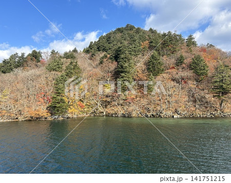 青森県十和田市の湖、十和田湖の遊覧船から見た陸地の小山の紅葉の景色です。 青森県十和田市の湖、十和田湖の遊覧船から見た陸地の小山の紅葉の景色です。 141751215