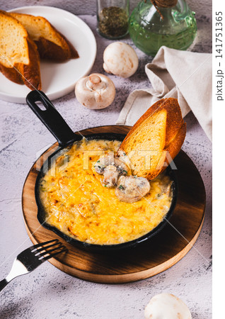 Mushroom julienne with cream and cheese crust in a frying pan on the table vertical view Mushroom julienne with cream and cheese crust in a frying pan on the table vertical view 141751365