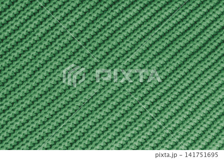 Close up, macro green knitted fabric texture with diagonal yarn stitches, cloth wool background Close up, macro green knitted fabric texture with diagonal yarn stitches, cloth wool background 141751695