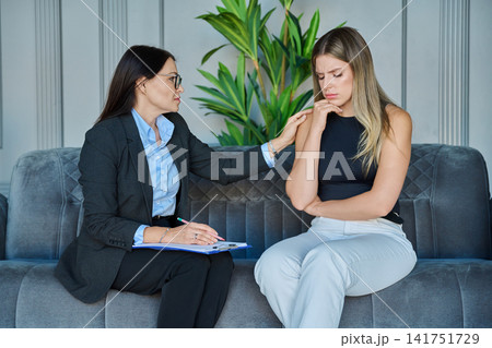 Professional Psychologist Comforting Depressed Female Patient During Therapy Session Professional Psychologist Comforting Depressed Female Patient During Therapy Session 141751729