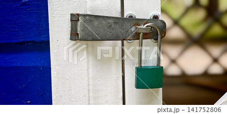 Lock secured on a white door with blue and brown paint in the background Lock secured on a white door with blue and brown paint in the background 141752806