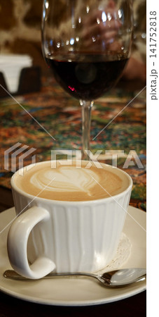 Coffee cup and wine glass on a table with a colorful background 141752818