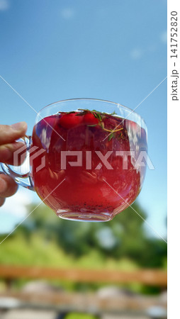 Cranberry ginger herbal tea on a sunny day in an outdoor setting Cranberry ginger herbal tea on a sunny day in an outdoor setting 141752820