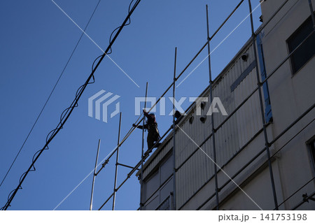 青空に向かって伸びる足場と建設作業員のシルエット、工事現場のイメージ 141753198