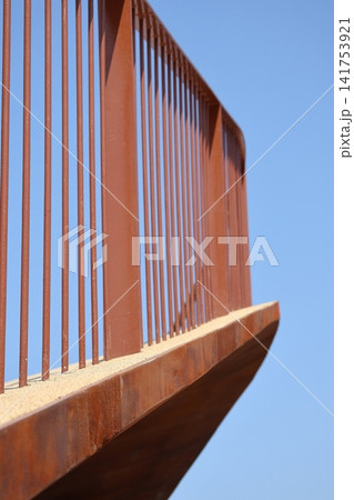 Rusty metal bridge railing against clear blue sky Rusty metal bridge railing against clear blue sky 141753921