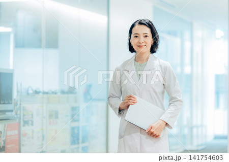 ノートパソコンを持つ白衣の女性 ノートパソコンを持つ白衣の女性 141754603