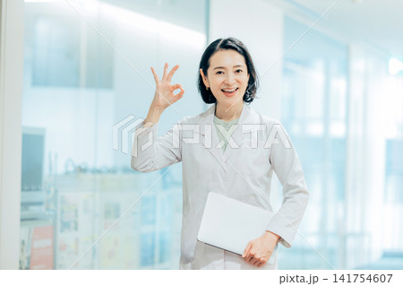 ノートパソコンを持つ白衣の女性 141754607