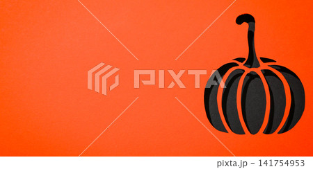 Halloween. Black pumpkin cutout showcases Halloween spirit in vibrant orange backdrop Halloween. Black pumpkin cutout showcases Halloween spirit in vibrant orange backdrop 141754953